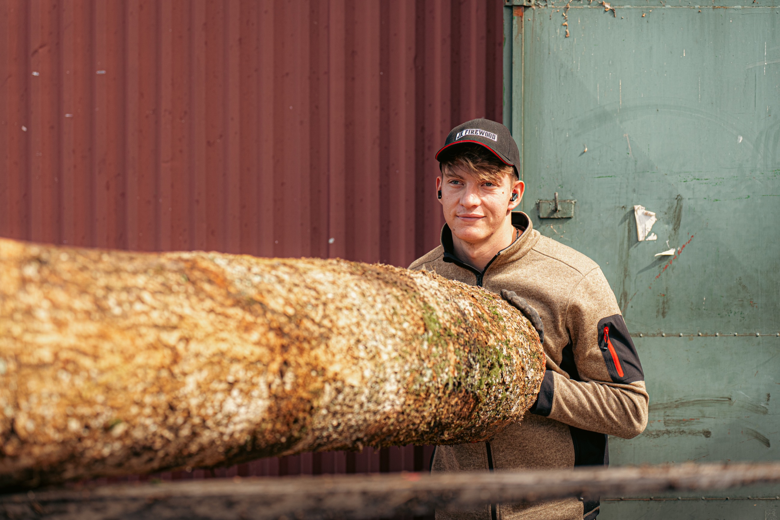 Jeremias schiebt einen Baumstamm in den Häcksler
